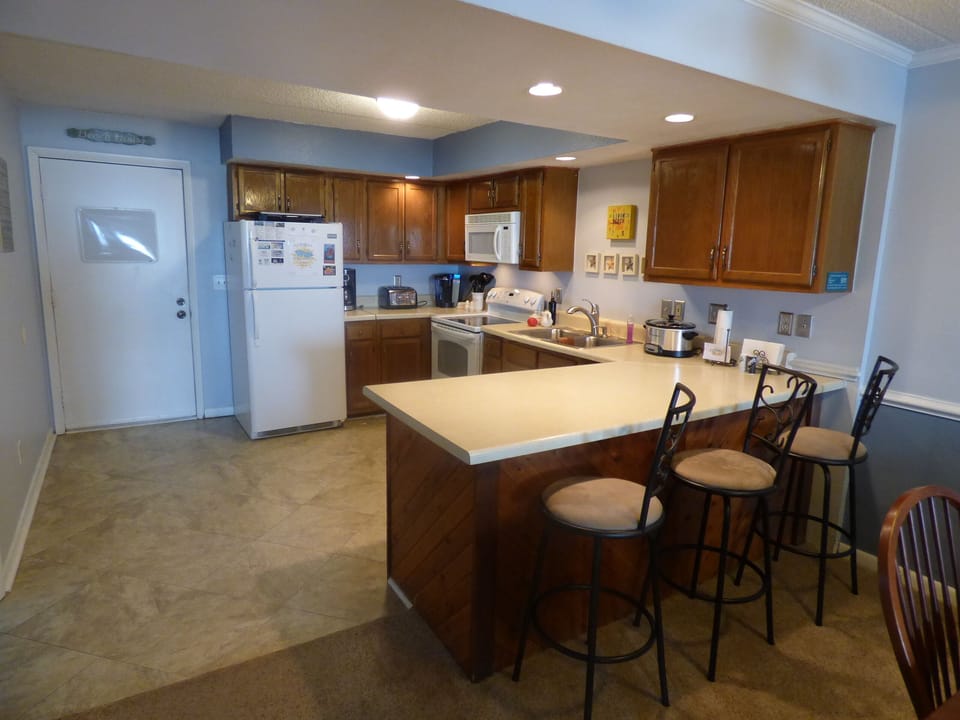 A well stocked kitchen with a Keurig coffee maker, crock pot, griddle and more.