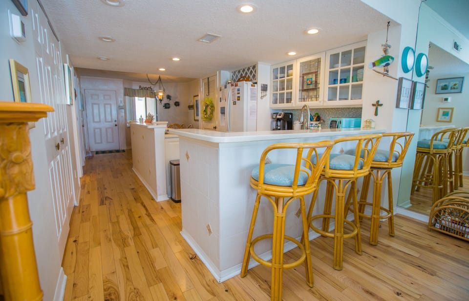 Hardwood floors, kitchen bar and bar stools.