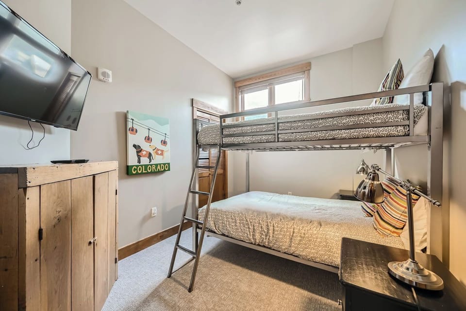 Fourth bedroom with full-size bunks and slope views
