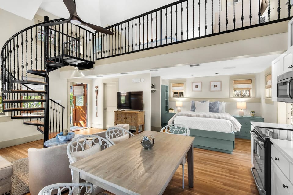 Spacious open living and dining area with elegant spiral staircase