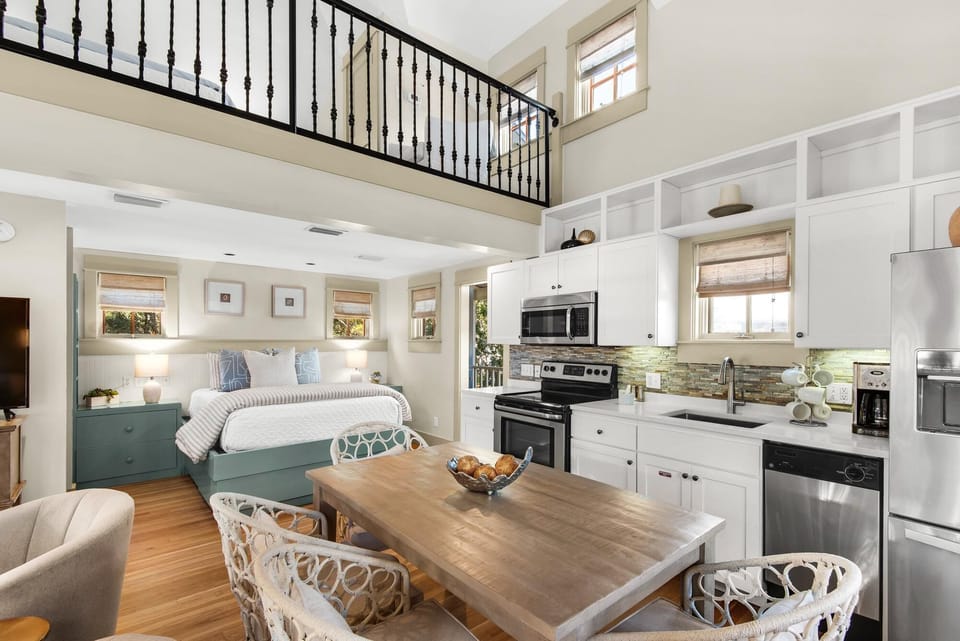Bright open-concept kitchen and dining area with cozy loft bedroom above
