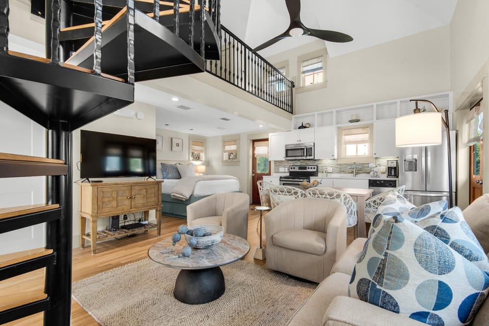 Bright and airy living room with cozy seating and loft access