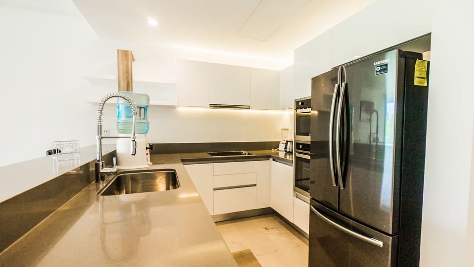 Deluxe Condo, Non Smoking | Private kitchen | Full-size fridge, microwave, oven, stovetop