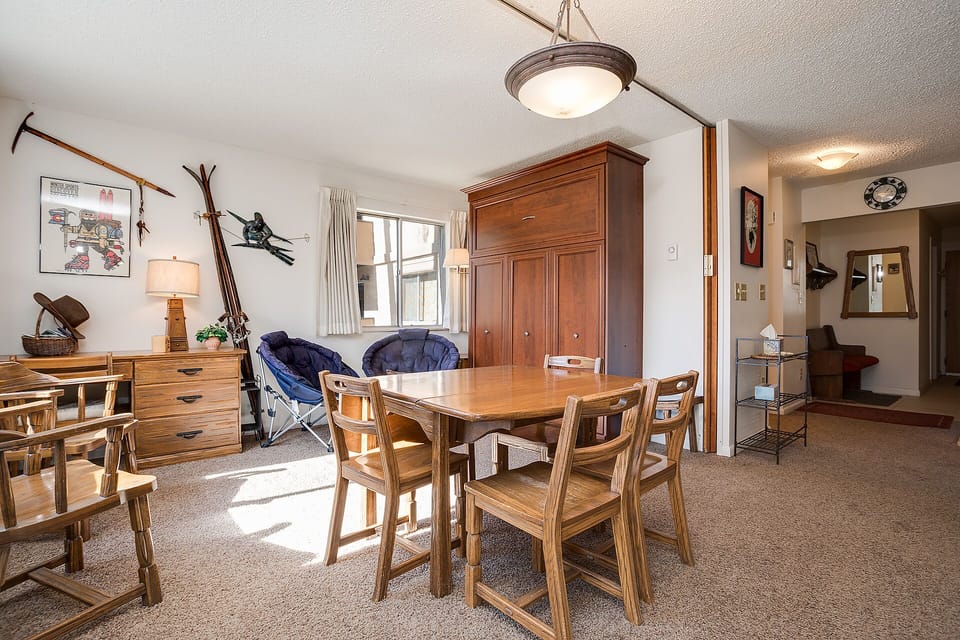 Gather around your rustic wooden dining table where ski-themed decor and warm mountain lodge charm create perfect après-ski memories.