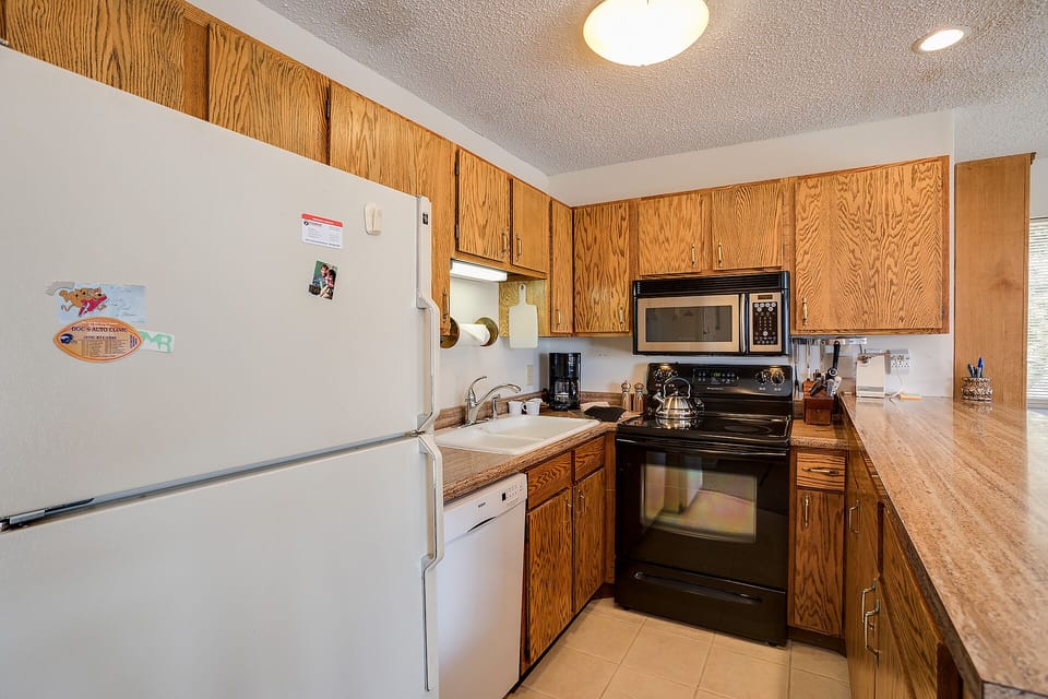 Your fully equipped kitchen awaits with warm wood cabinetry, full appliances, and plenty of counter space for preparing memorable meals together.
