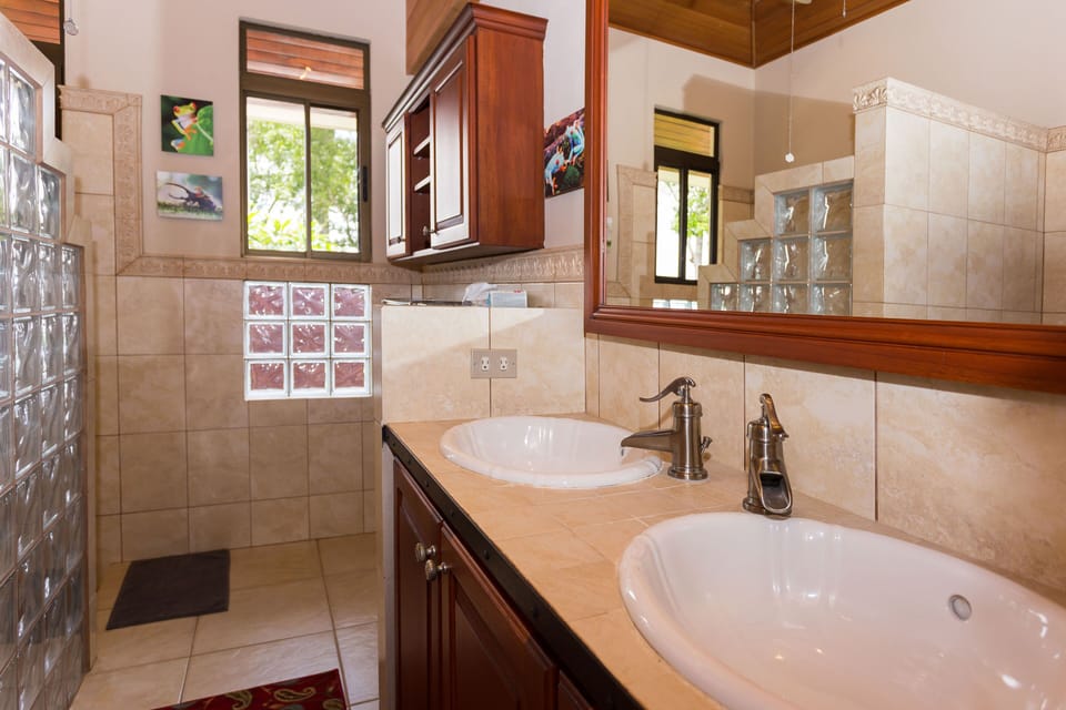 Shared bath with glass block shower and double sinks.