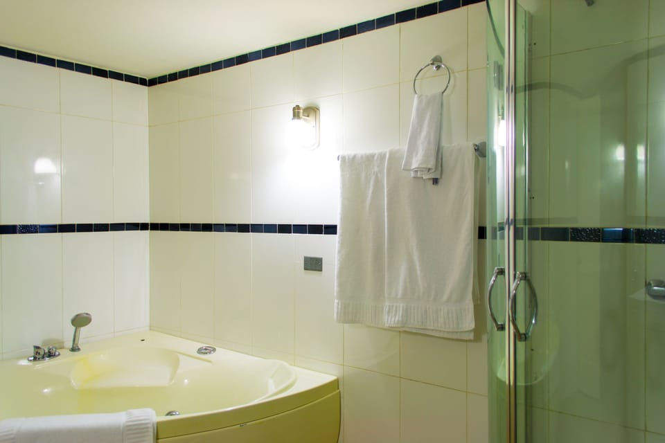 Junior Suite, 1 King Bed, Non Smoking | Bathroom | Separate tub and shower, rainfall showerhead, free toiletries, towels