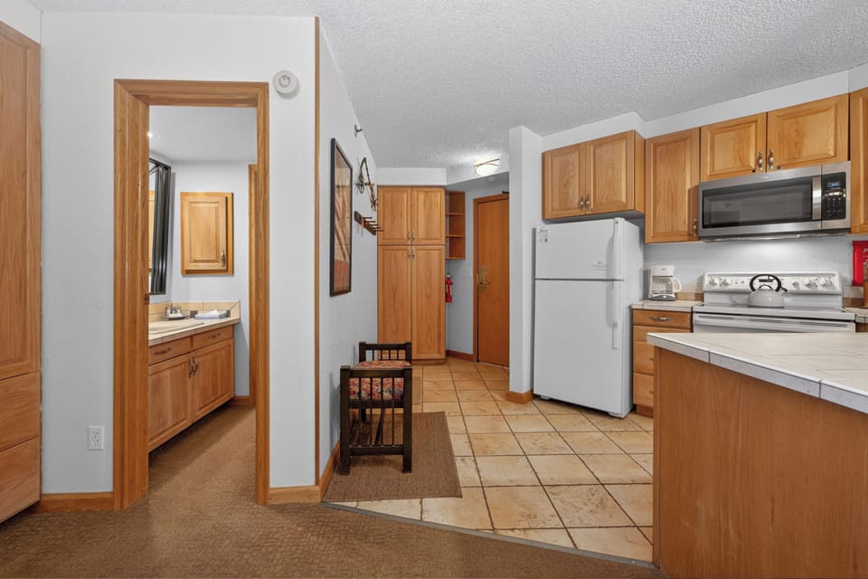 Step into your fully equipped kitchen where you'll find everything you need to cook and enjoy meals at home, with warm oak cabinetry and modern appliances ready for your arrival.
