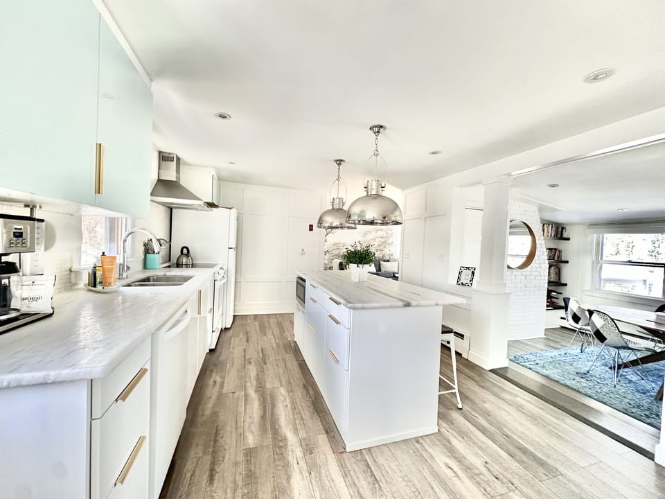  Large kitchen with center island & seating for three. Carrera marble counters.
