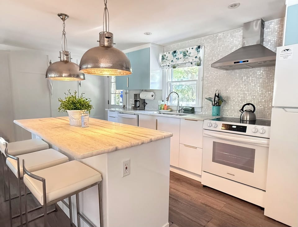  Large kitchen with center island & seating for three. Carrera marble counters.