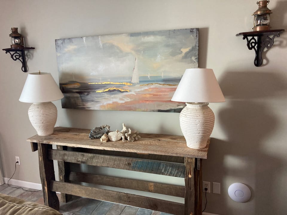 Living Room antique sofa table with lamps, and antique brass wall sconces. 
