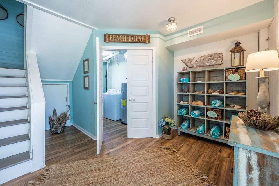 1st level entry with washer & dryer game accessories and beach towels.