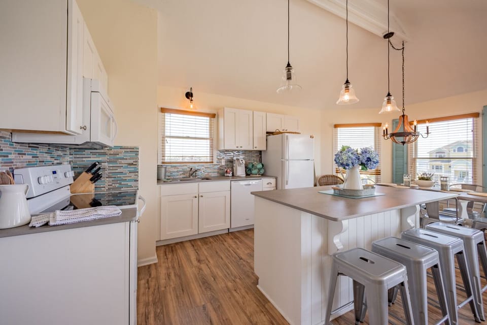 Full kitchen with island and concrete countertops. 