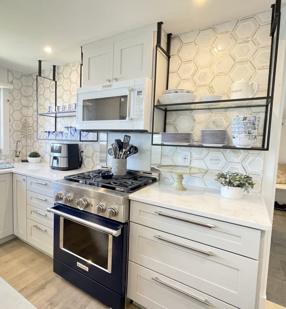 Navy blue KitchenAid gas range with KitchenAid microwave above. 