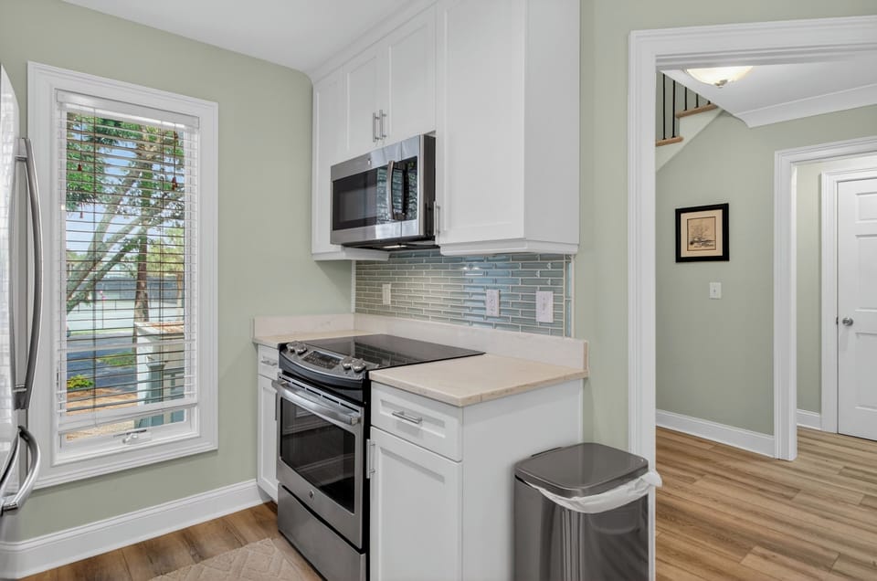Your fully equipped kitchen features modern stainless steel appliances, stylish white cabinetry, and elegant quartz countertops. Prepare your favorite meals while enjoying natural light streaming in.