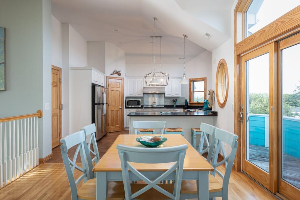 Dining table looking into the open full service kitchen. 