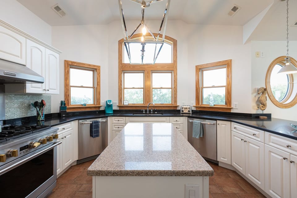 Large gas stove and island work area.