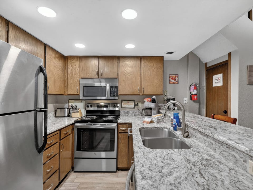 Your fully equipped kitchen features granite countertops, stainless steel appliances, and warm wood cabinetry—perfect for preparing memorable meals during your stay.