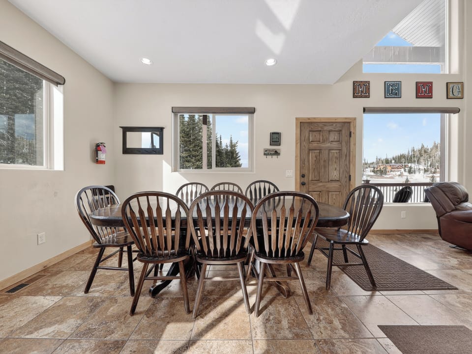 Gather around this spacious dining table for memorable meals while enjoying stunning mountain views through picture windows that frame the snowy landscape.