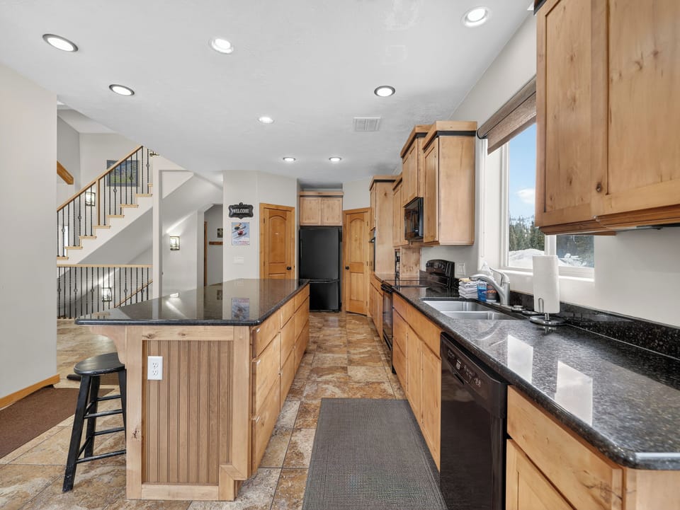 Step into your fully equipped kitchen with warm wood cabinets, granite counters, and modern appliances - perfect for cooking memorable meals together.