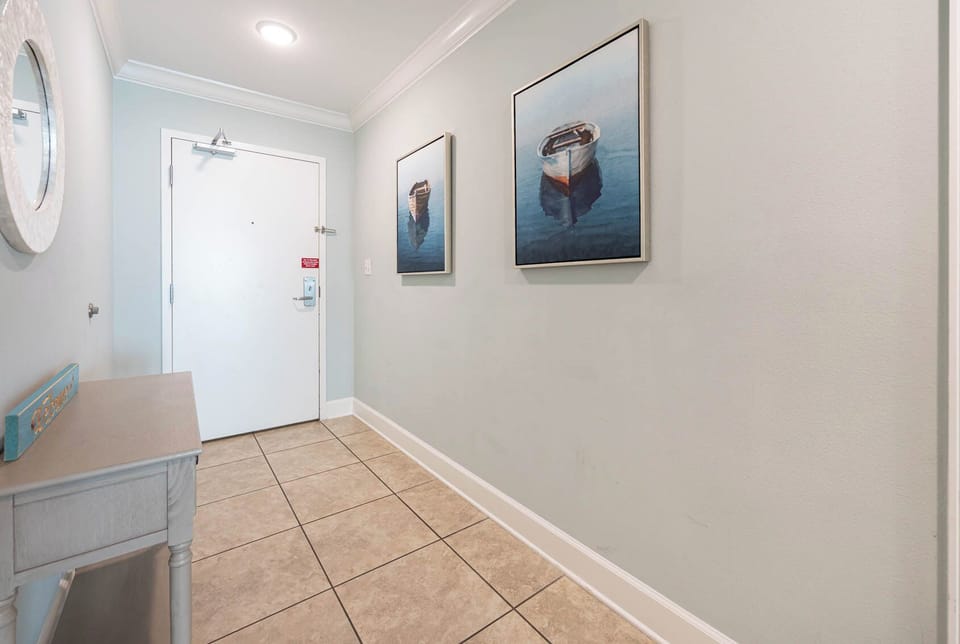 Step into a welcoming hallway adorned with serene coastal art, setting a tranquil tone for your beach escape
