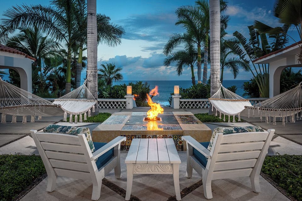 Gas fire table framed by hammocks and palms facing the Sea of Cortez at Casa Edwards, Palmilla