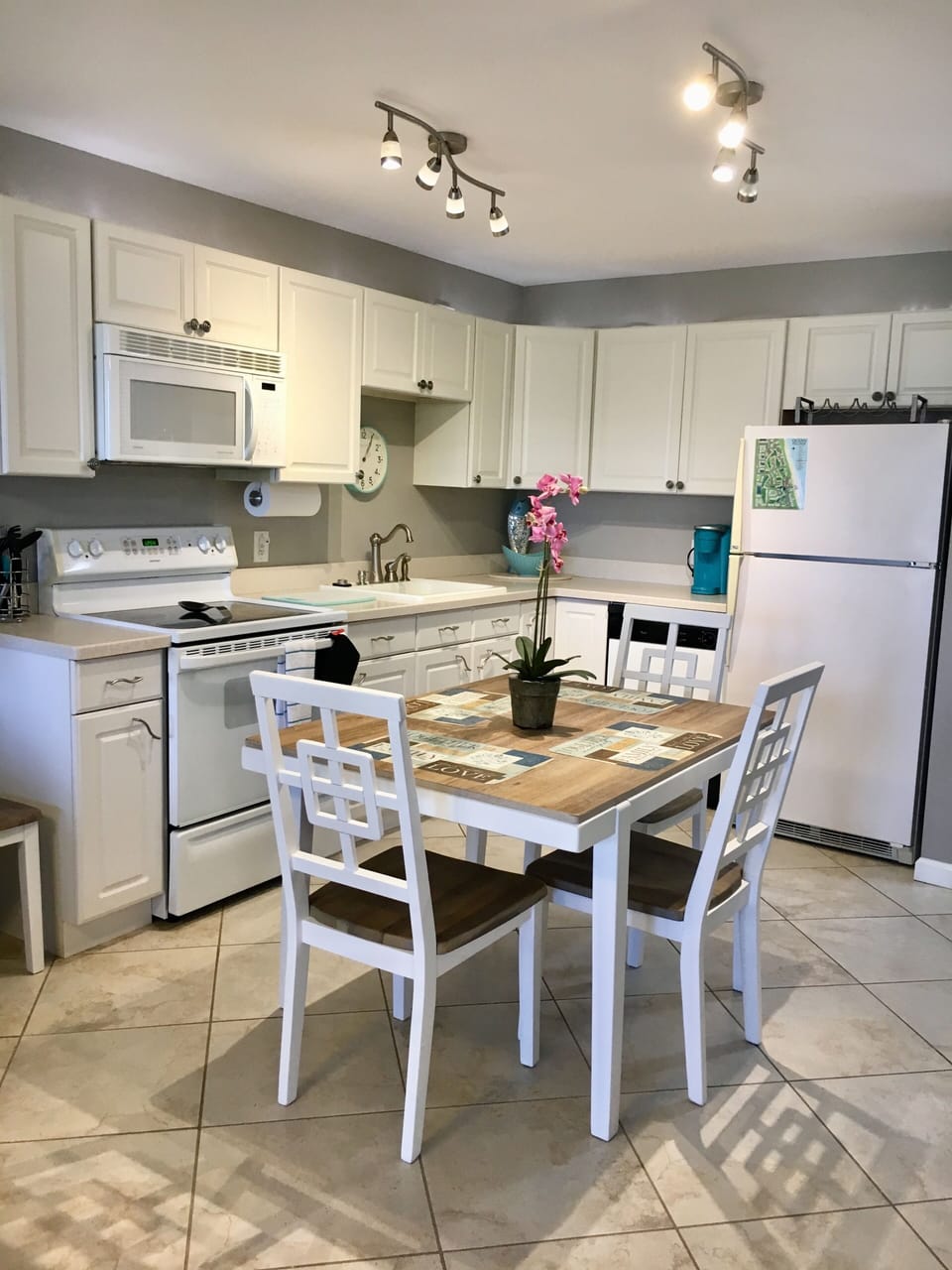Bright, spotless kitchen equipped with full- sized refrigerator and dishwasher 