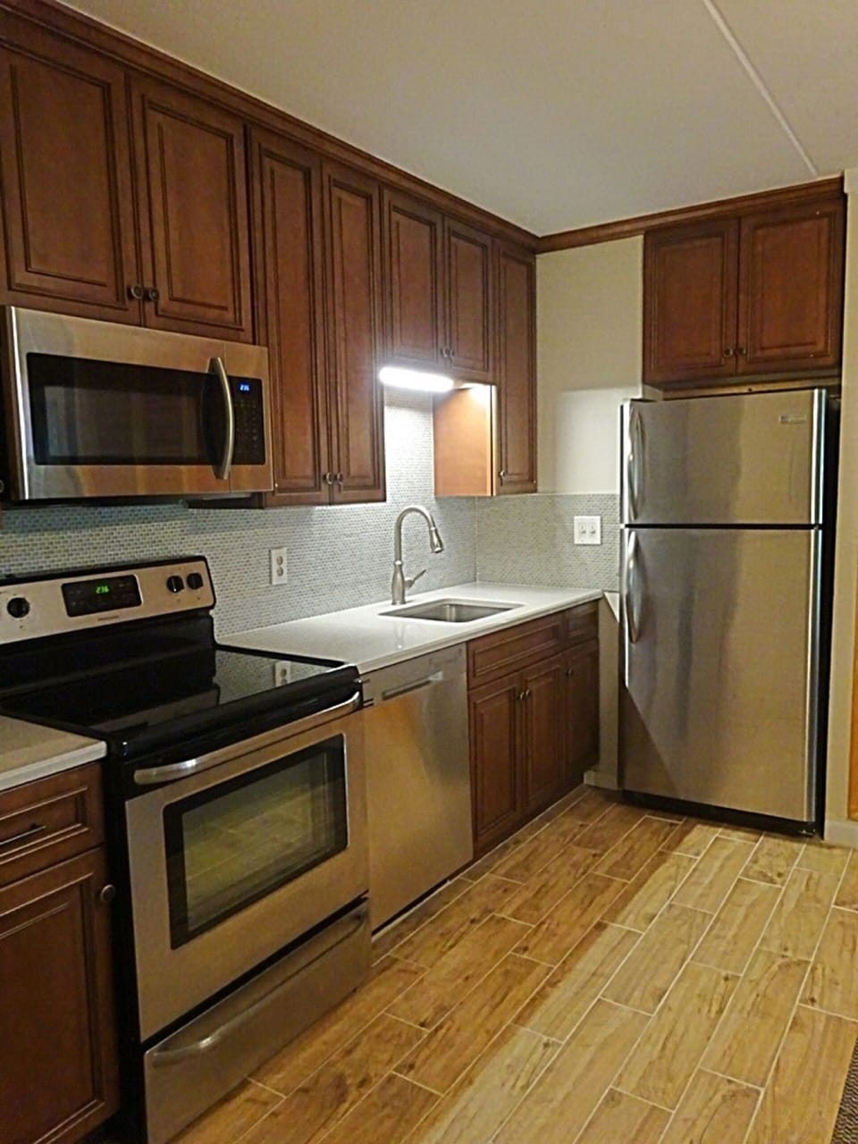 New cabinets, quartz countertop, tiled backsplash, & stainless steel appliances