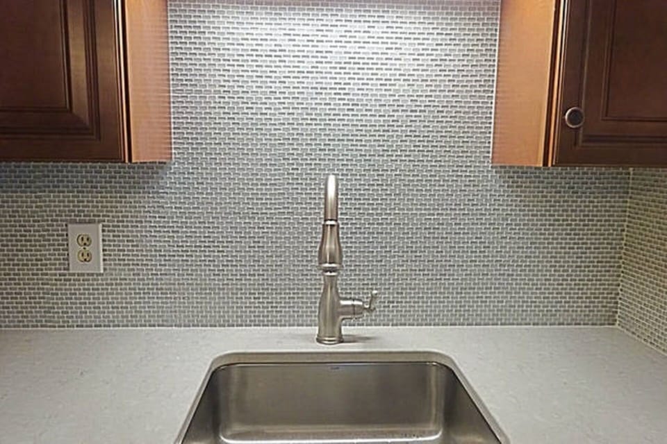 beautiful glass tile backsplash and quartz countertop. 
