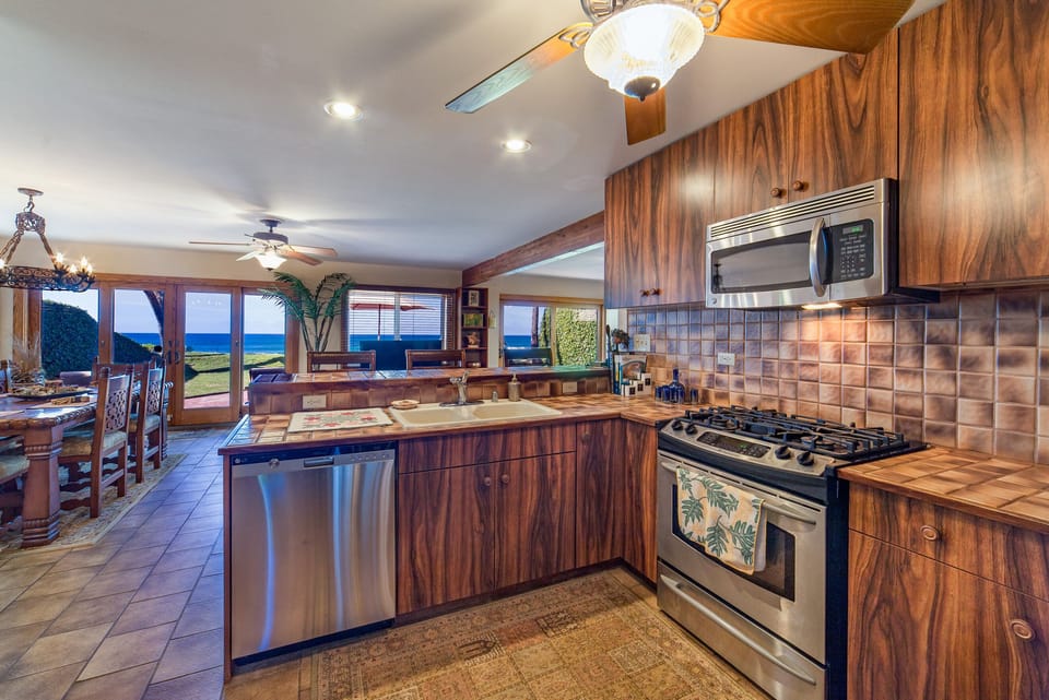 Gourmet Open Kitchen with custom Koa Wood cabinets & stainless steel appliances.