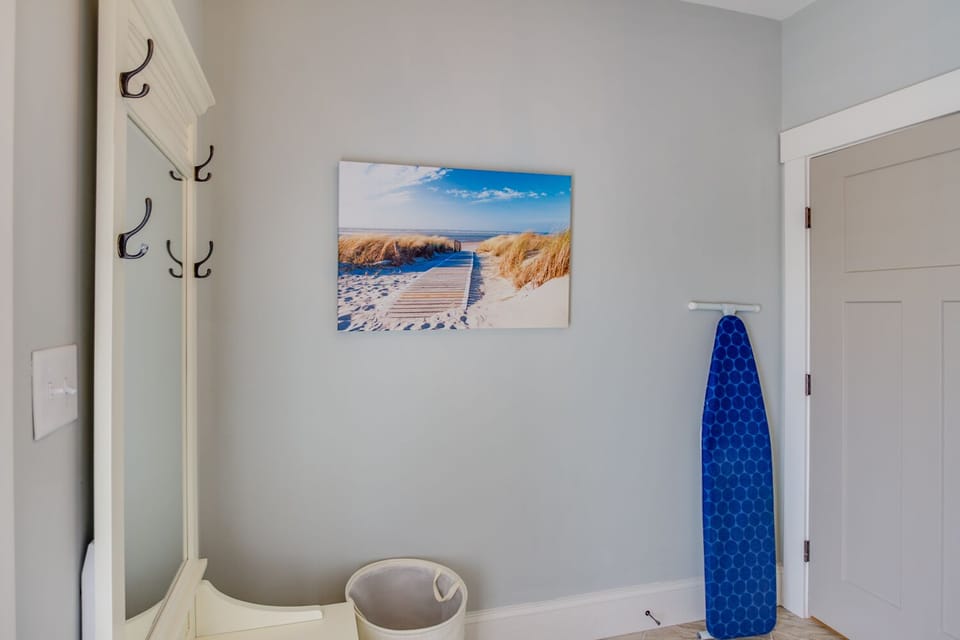 Laundry room with iron, ironing board and laundry detergent.