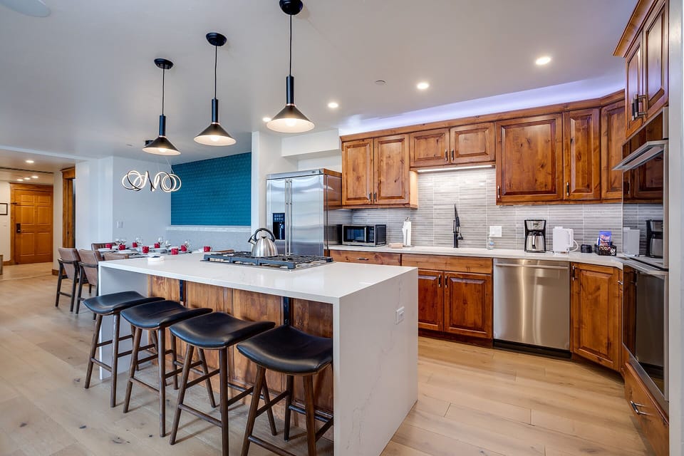 Your gourmet kitchen awaits with rich wood cabinets, sleek pendant lights, and a spacious island perfect for gathering with loved ones.