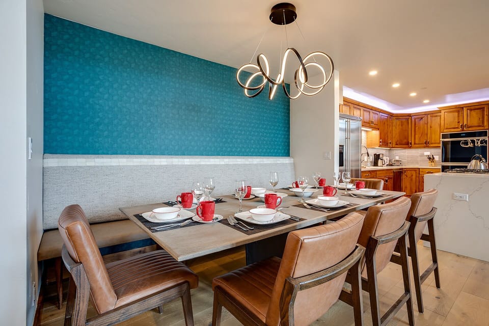 Gather around your elegant dining table beneath sculptural lighting, where memorable meals await in this sophisticated space.