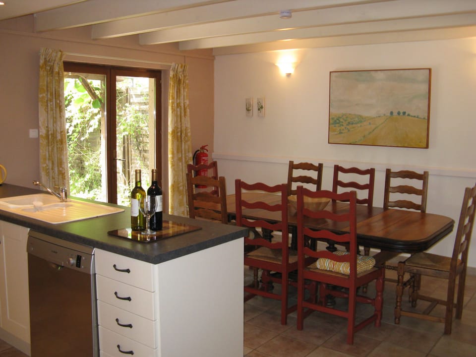 Kitchen and dining area in La Grange with doors opening onto the courtyard