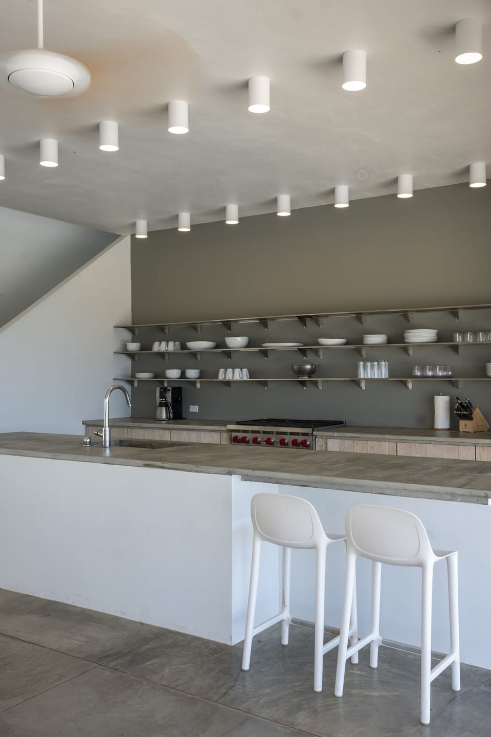 Kitchen with bar stools and open shelving.