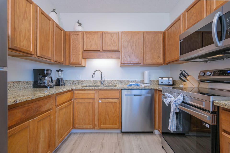 Cook and gather in the inviting kitchen with granite countertops and white appliances, perfect for meal preparation