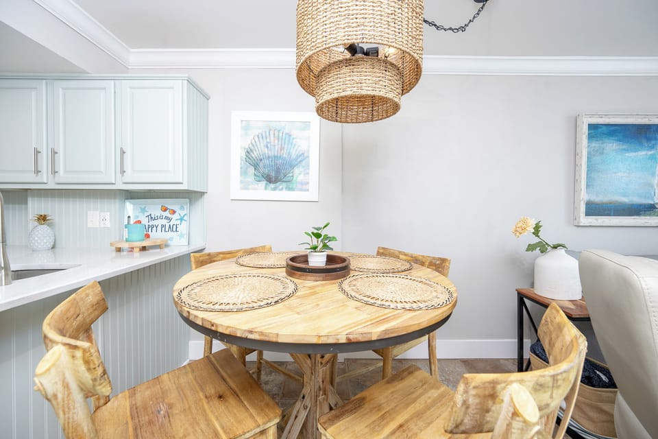 Inviting dining area featuring a rustic wooden table, woven placemats, and charming coastal decor