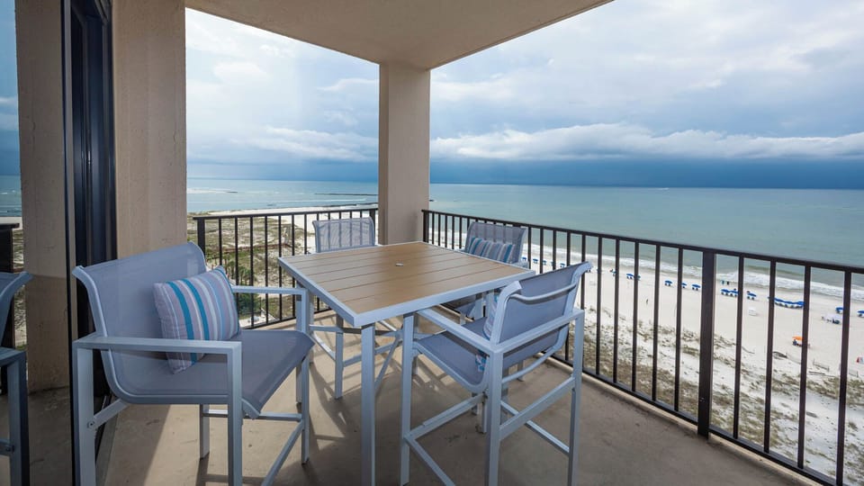 Enjoy meals or drinks at the outdoor balcony table while taking in the expansive views of the beach