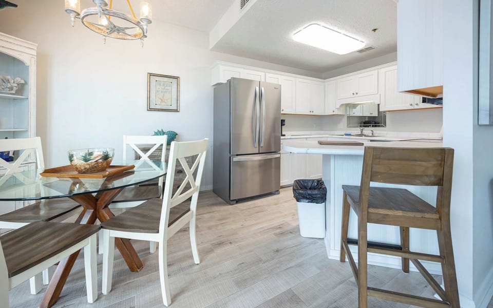 Gather around the glass dining table, surrounded by coastal decor, and enjoy meals in this inviting space