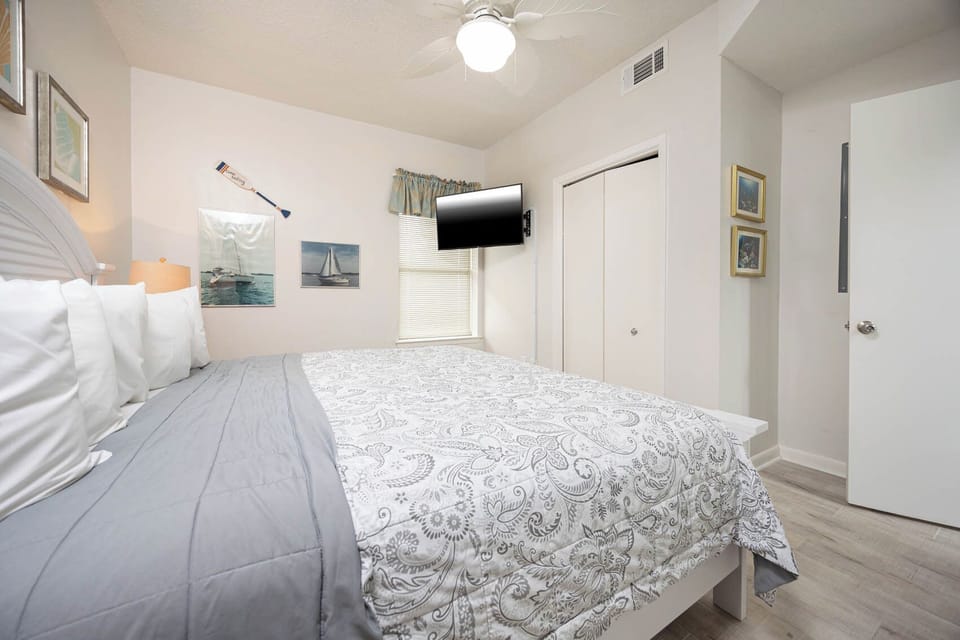 Relax in this inviting bedroom with a comfortable king bed, wall-mounted TV, and charming nautical decor
