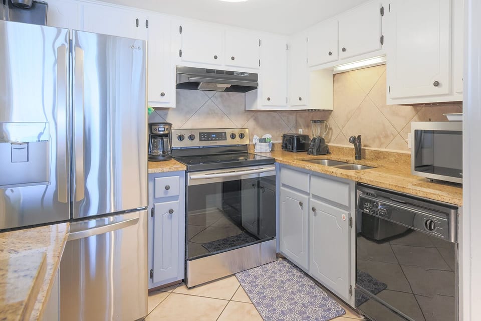 The kitchen features stainless appliances, granite countertops, and ample cabinetry for a delightful cooking experience
