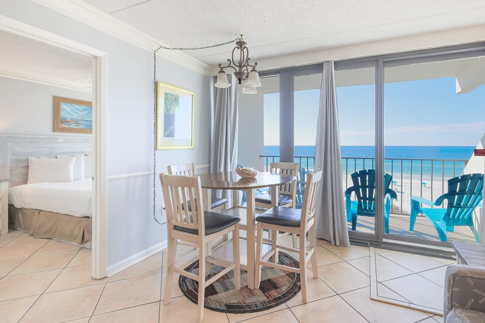 This inviting dining area features a round table and stunning beachfront views, perfect for enjoying meals and relaxation