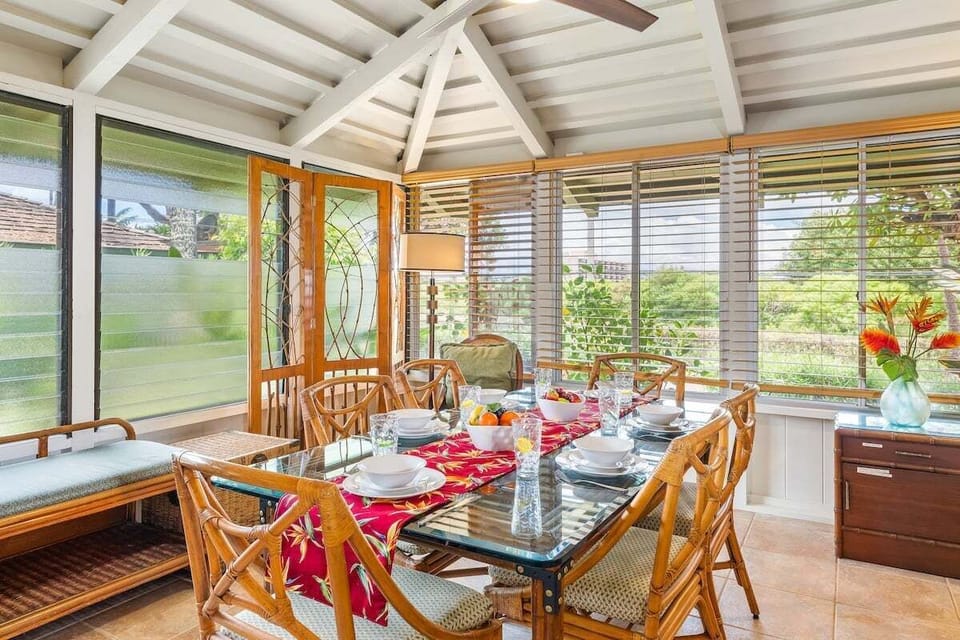 Tropical dining area with a table that seats six, enhanced by refreshing split AC and a ceiling fan.