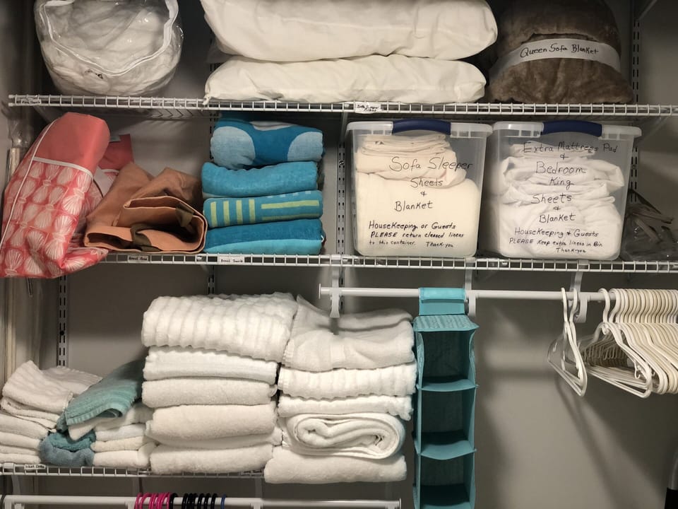 Bathroom closet with towels, extra sheets, blankets and beach towels. 
