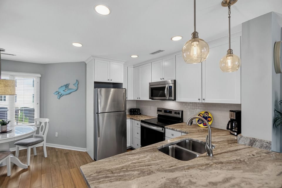 Step into your bright, fully equipped kitchen with stainless steel appliances, elegant granite countertops, and charming pendant lighting. Everything you need to whip up meals during your stay.