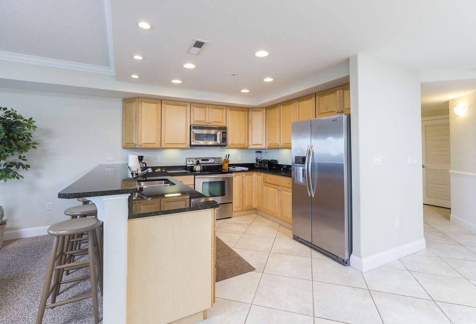 Kitchen boasts gleaming Granite & High-end Stainless Appliances.