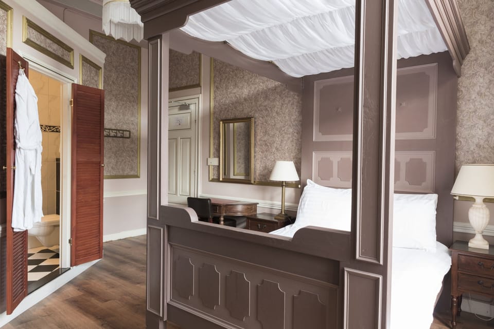 Comfort room with four-poster bed | In-room safe, individually furnished, desk, iron/ironing board