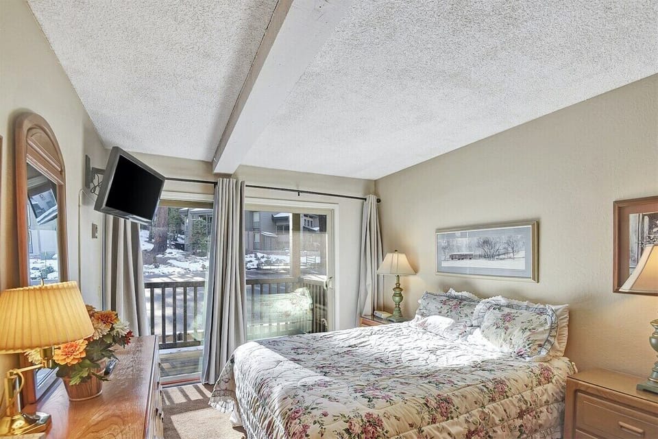 Primary bedroom with a queen bed, TV and deck
