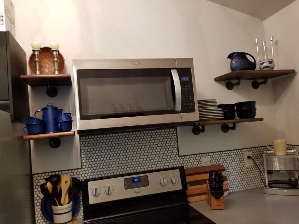 New modern kitchen with glass top range, convection oven, and microwave hood.