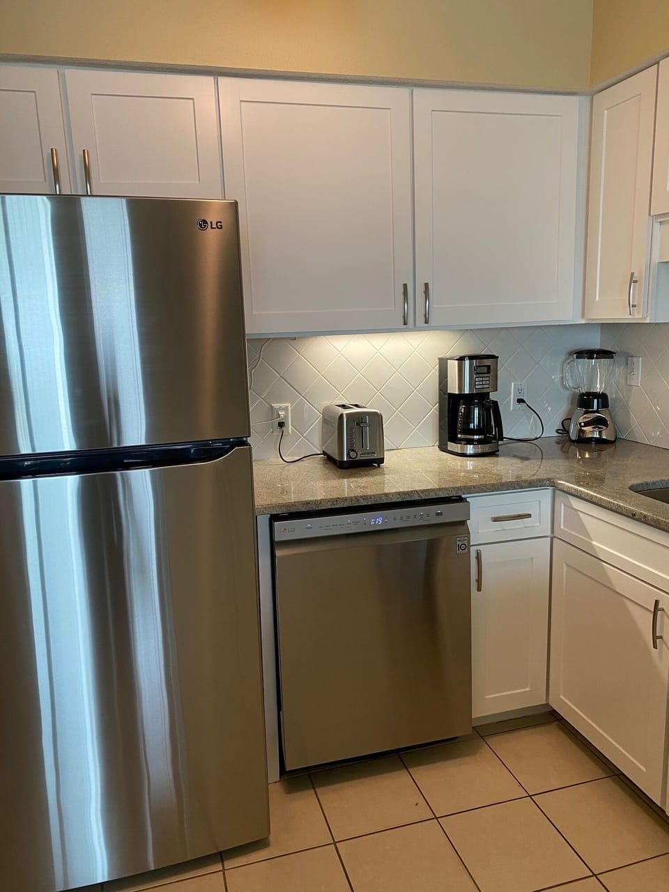 Shaker style cabinets, fridge with icemaker and small appliances in kitchen 